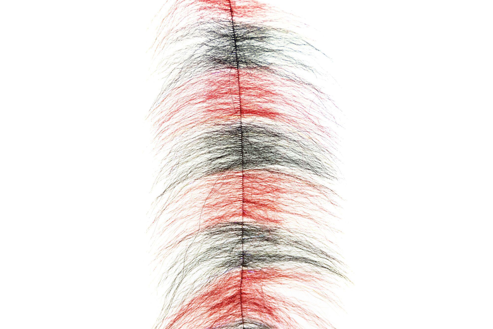 Long wispy grizzly fox hair brush with alternating red and black bands and central stitched spine for fly tying