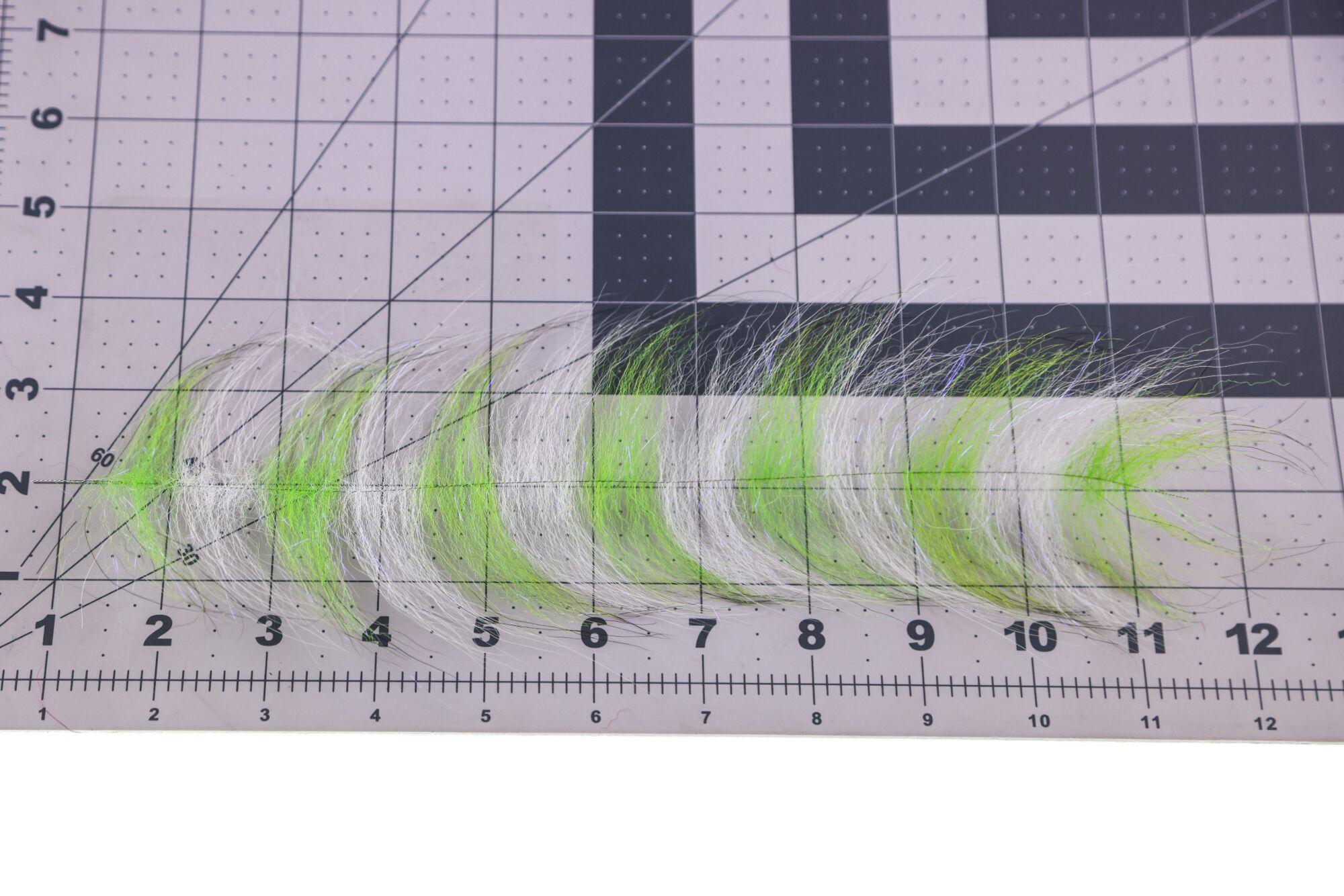White and chartreuse synthetic Grizzly Foxy brush fibers with iridescent flash laid on measuring mat for fly tying