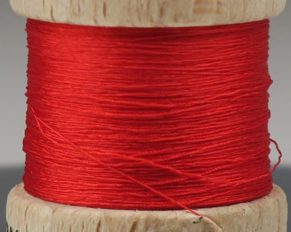 Bright red Ephemera pure silk thread wound on a wooden spool, glossy silk for fly tying
