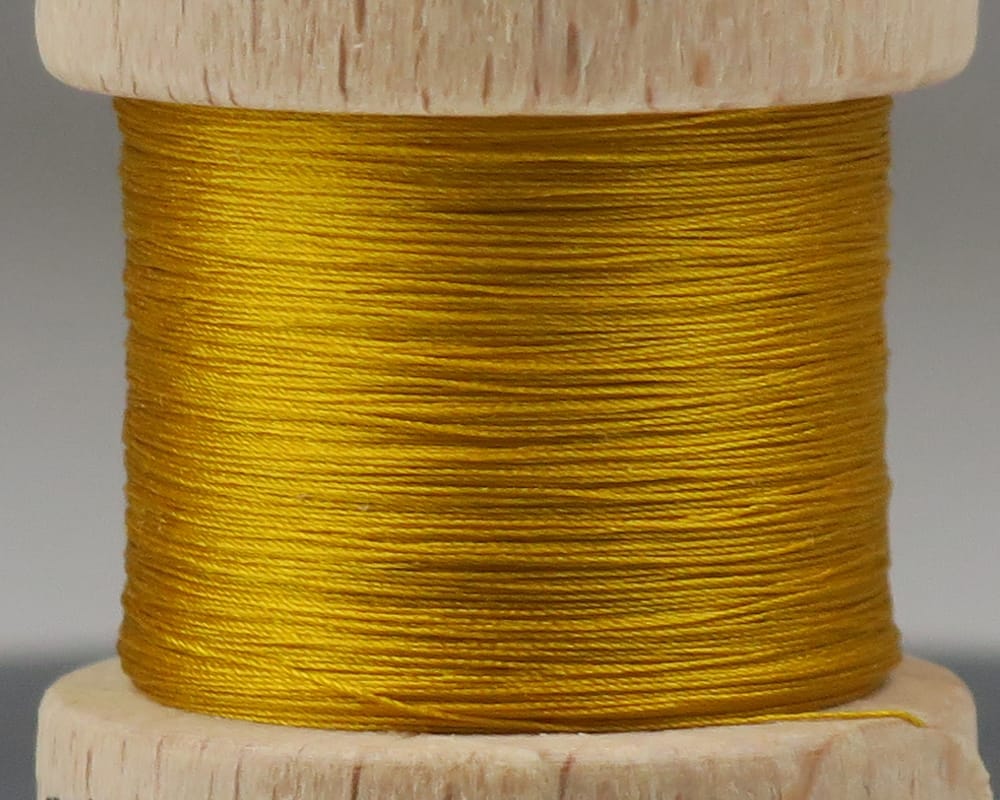 Golden yellow pure silk thread wound on wooden spool for fly tying