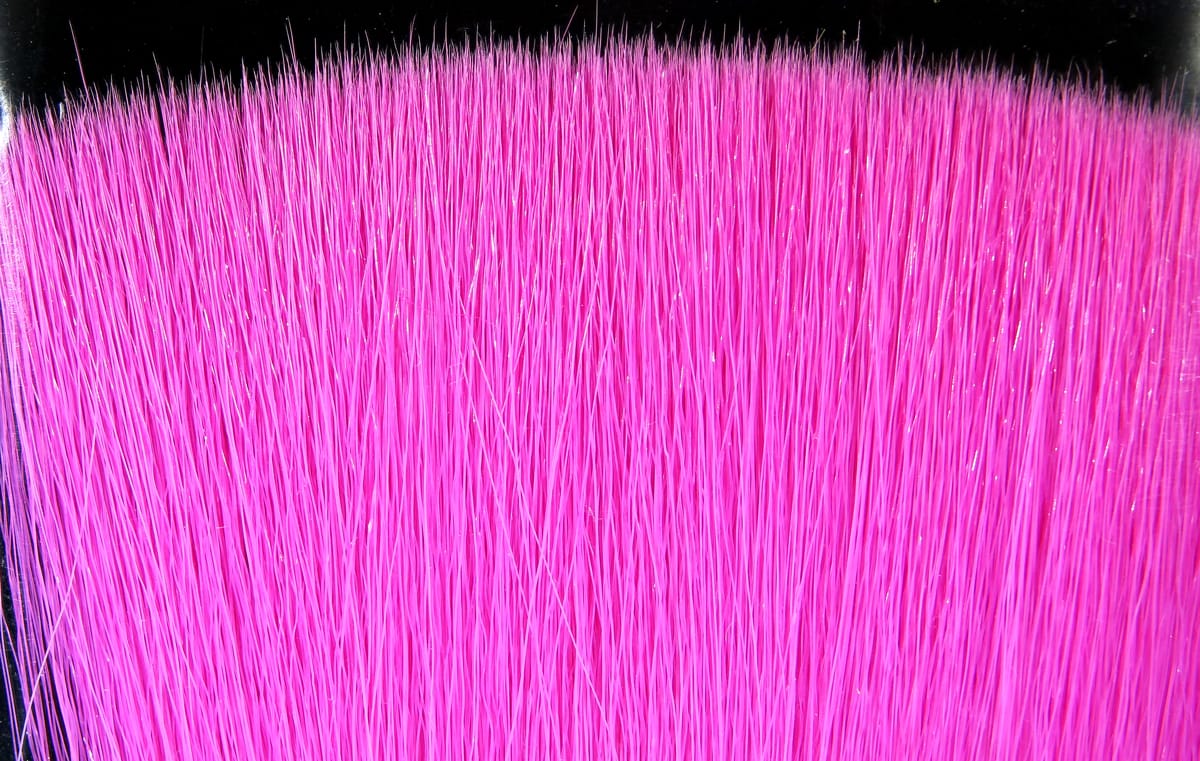 Vibrant hot pink synthetic faux bucktail fibers, dense glossy strip with long tapered strands for fly tying