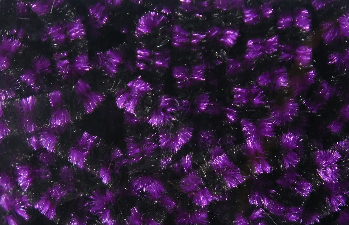 Black and purple metallic stonefly chenille with fuzzy tufted synthetic fibers for fly tying