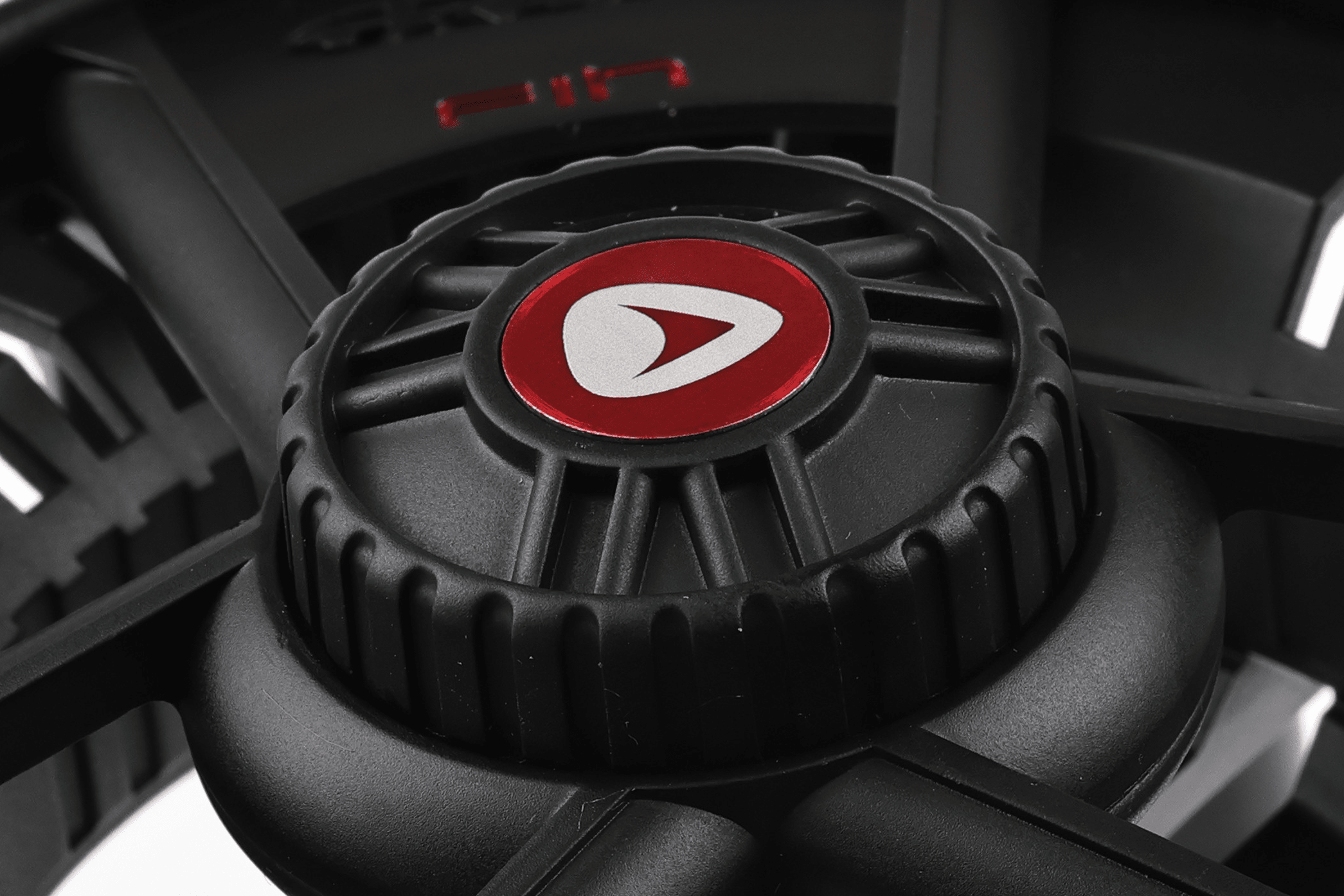 Black matte Greys Fin fly reel close-up showing red logo on textured knurled drag knob and spoked frame