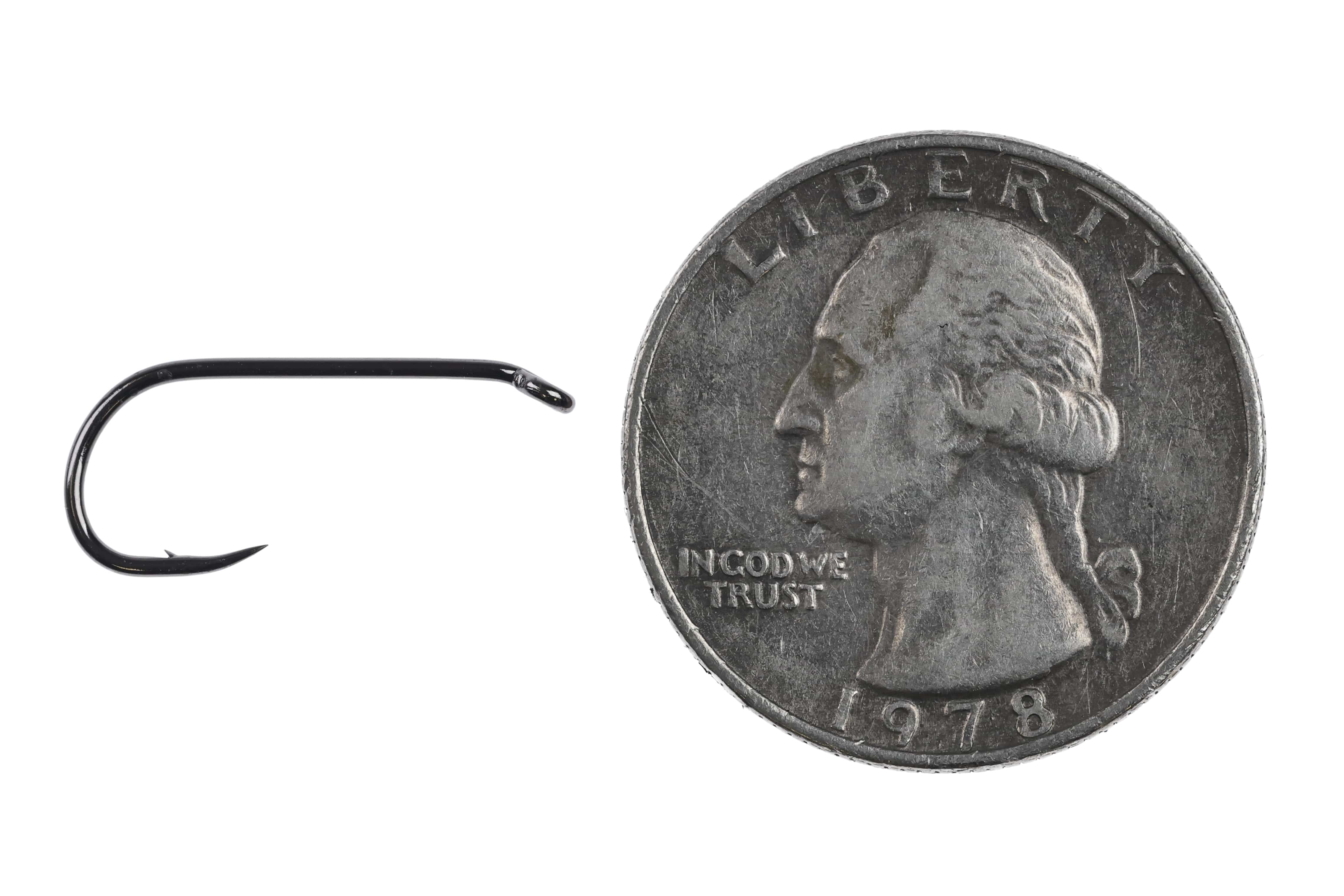 Black short-barbed metal nymph hook (Ahrex FW562) with curved shank beside US quarter for scale, fly tying hook