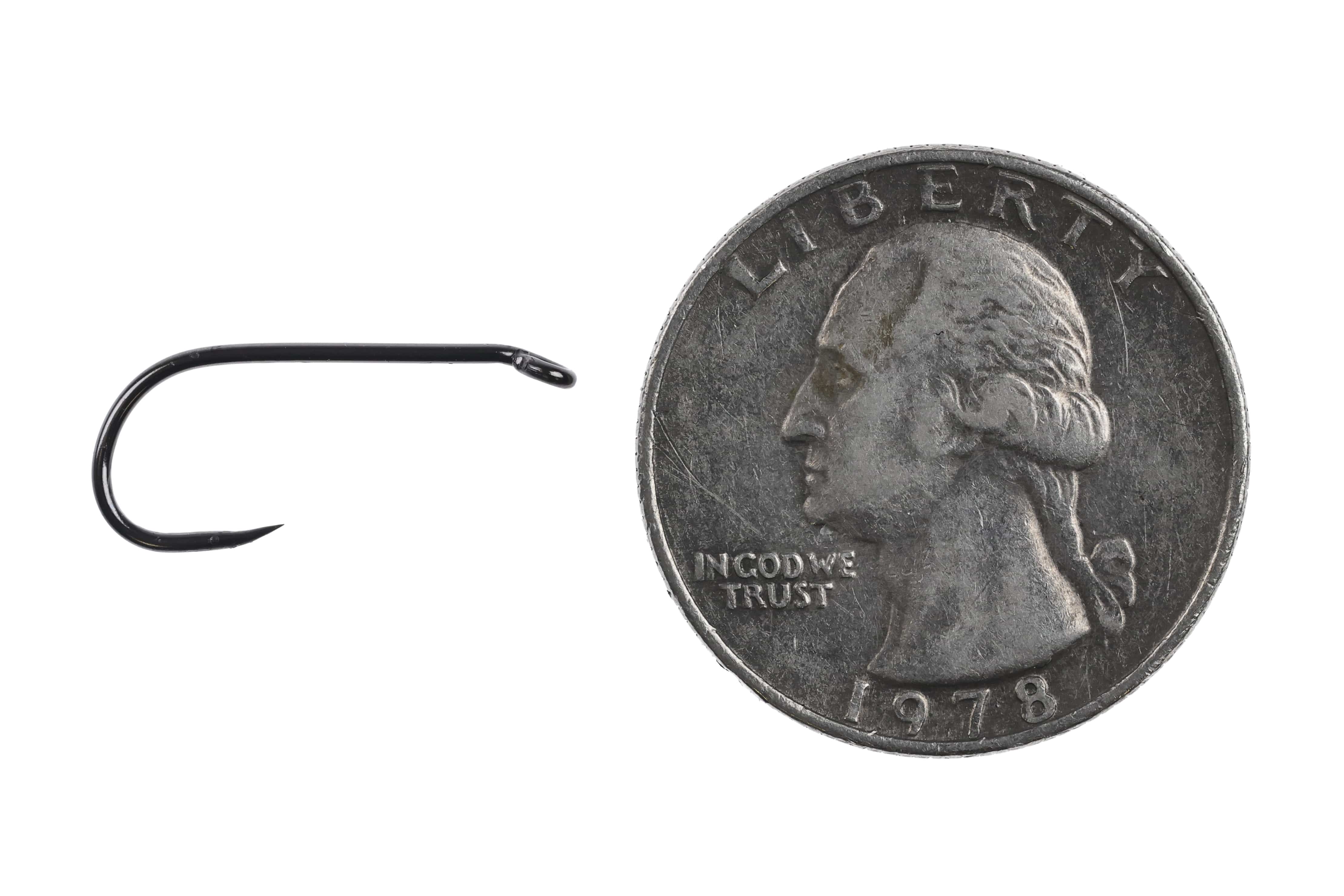 Black metal short-shank barbless nymph hook with closed eye and round bend beside US quarter for scale