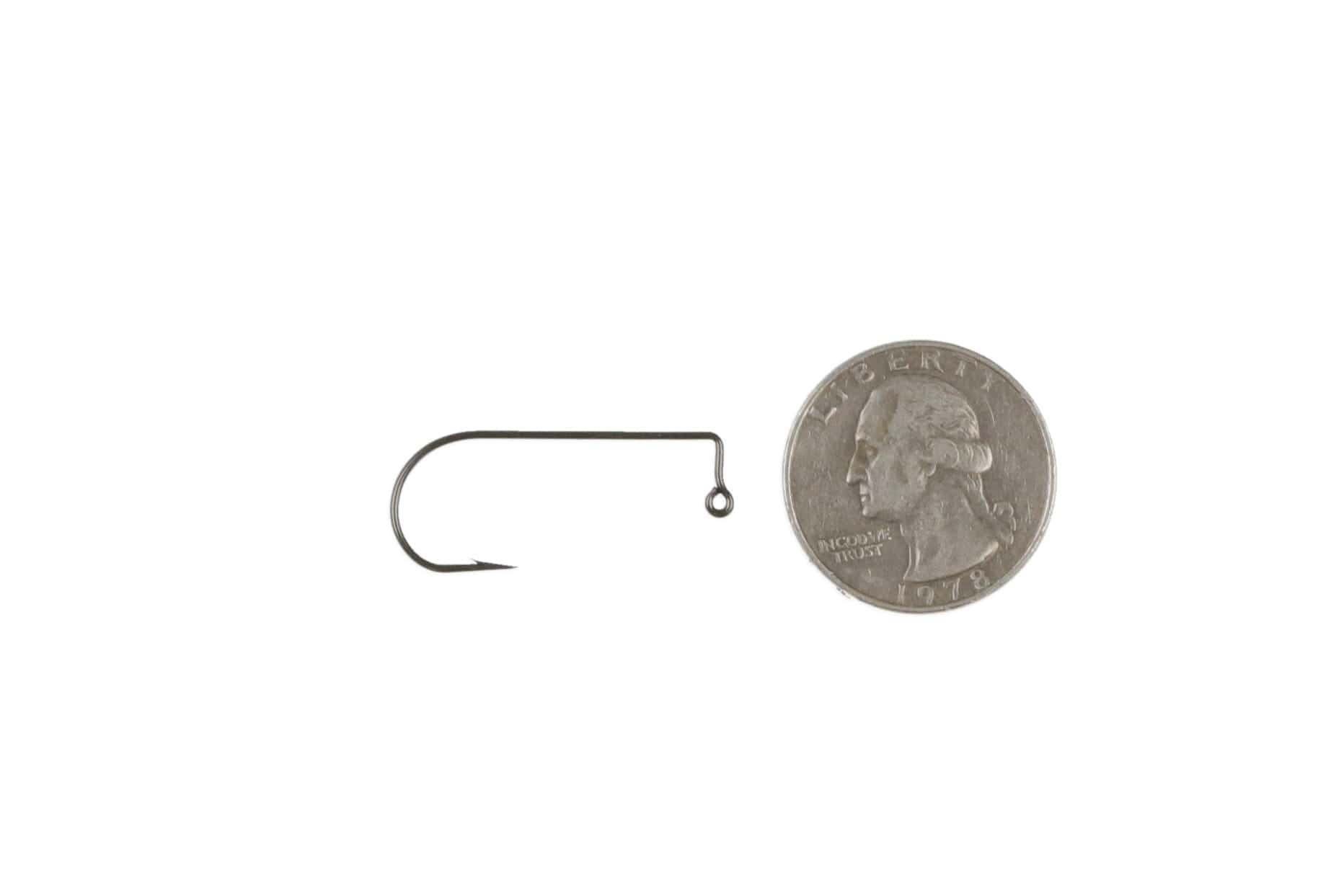 Black nickel 90° Aberdeen jig hook with up-eye, thin curved shank and sharp point beside US quarter for scale, fly tying
