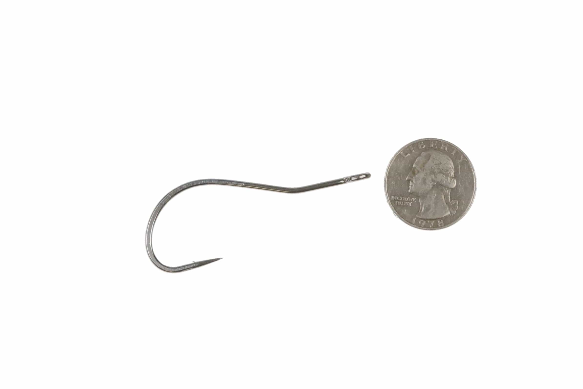 Silver Ahrex SA258 bendback fly-tying hook with upturned eye and sharp point beside a US quarter for scale