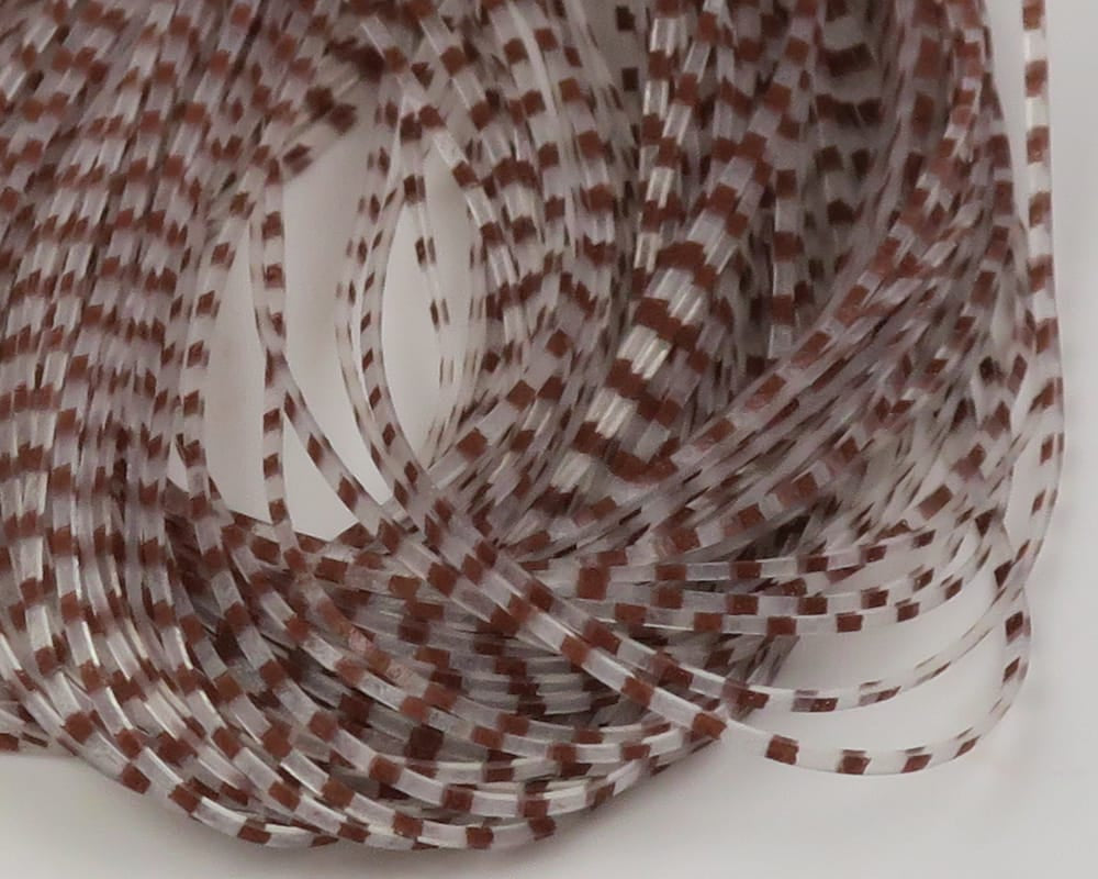 Coiled translucent white synthetic crusher legs with brown barred check pattern for fly tying