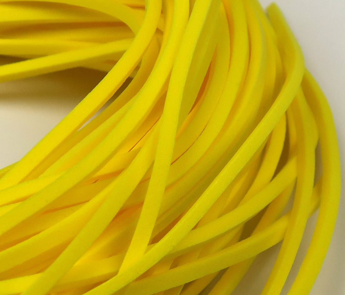 Bright yellow fettuccine foam strips for fly tying, thin flattened foam ribbons with smooth spongy texture