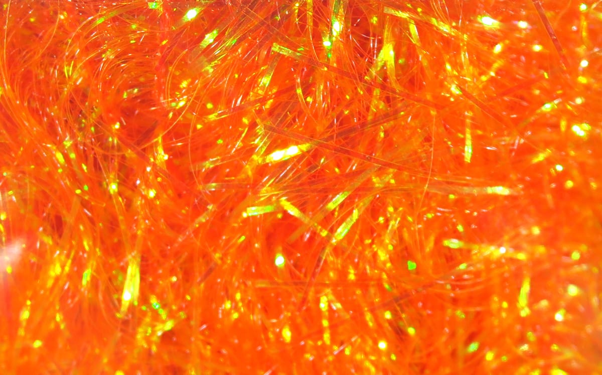Bright orange iridescent synthetic flash fibers for fly tying, fine shredded filler with green-gold shimmer