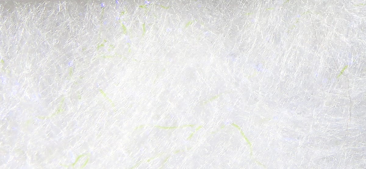 White synthetic Bruiser Blend dubbing with fine fluffy fibers, subtle lime and iridescent strands for fly tying