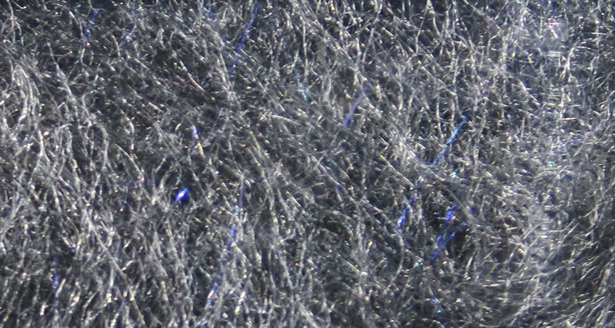 Charcoal gray Bruiser Blend dubbing with fine synthetic fibers and blue iridescent flashes for fly tying