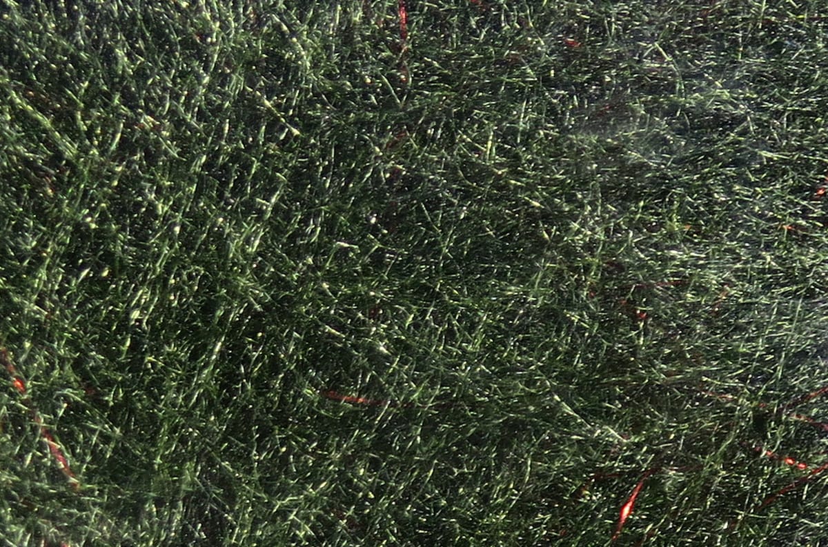 Dark olive green synthetic Bruiser Blend dubbing with fine fur-like fibers and red flash strands for fly tying