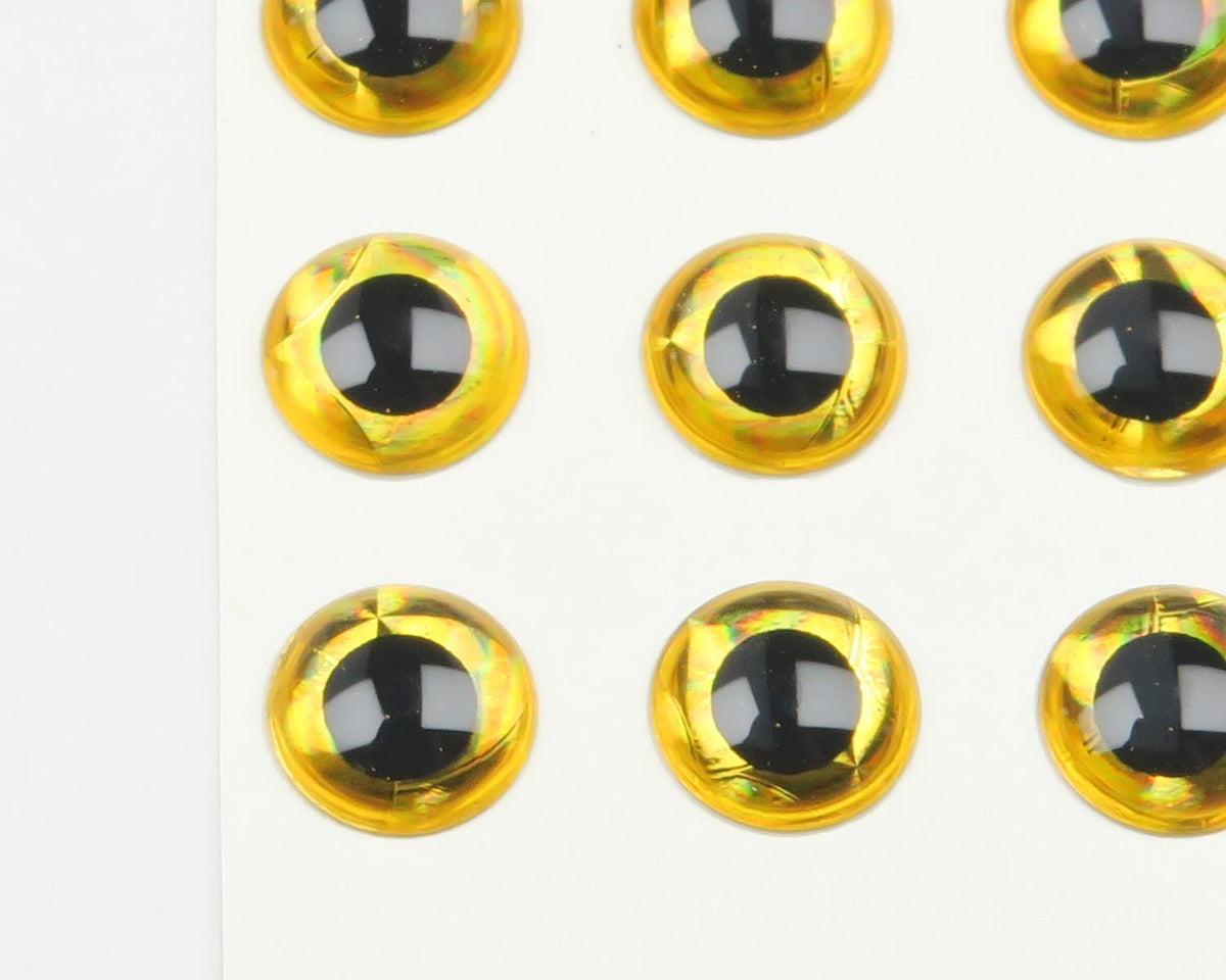 Gold holographic 3D adhesive eyes with black pupils on white backing sheet for fly tying