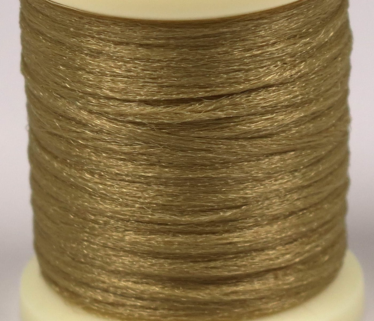 Shimmering olive-brown Hareline Antron yarn spool with fine synthetic fibers for fly tying