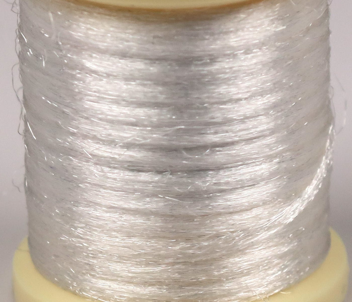 Pearl white Hareline Antron yarn on spool, shiny translucent synthetic fibers for fly tying