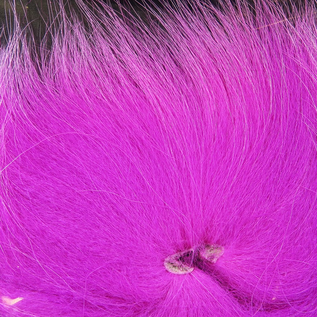 Bright magenta arctic fox tail hair with long soft guard hairs and dense fluffy underfur for fly tying