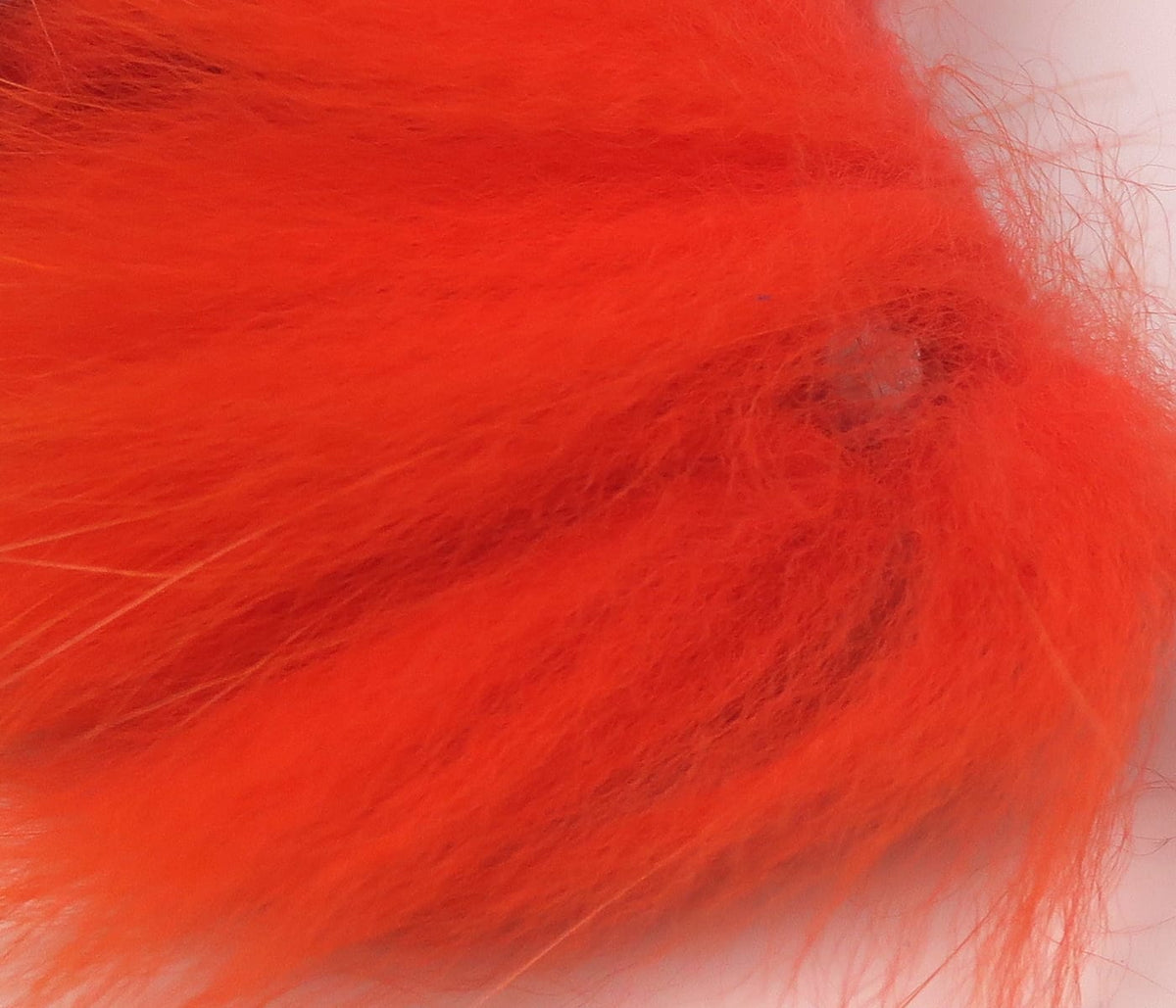 Bright orange Arctic fox zonker strip with long soft fur fibers, plush texture for fly tying