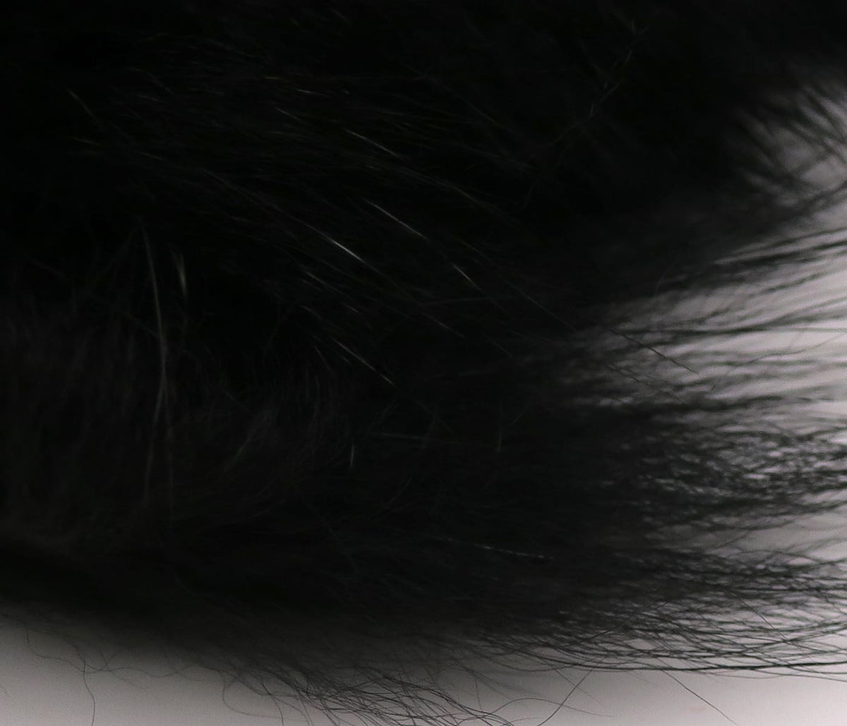 Black Arctic fox zonker strip with long glossy fur fibers, soft material for fly tying and streamer patterns