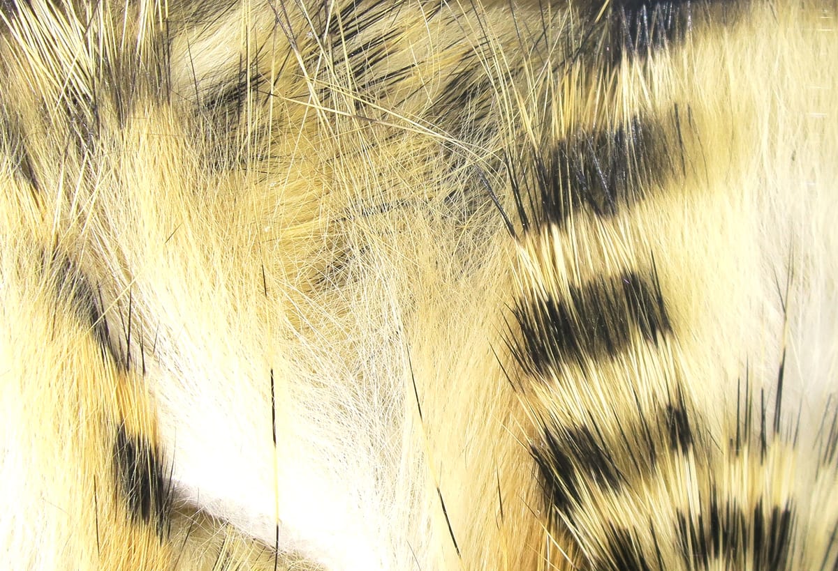 Hareline black-barred rabbit fur strips: tan and cream fur with bold black bars and long guard hairs for fly tying