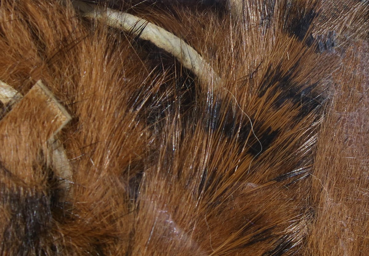 Hareline black-barred rabbit fur strips: reddish-brown rabbit fur with black bars and glossy guard hairs for fly tying