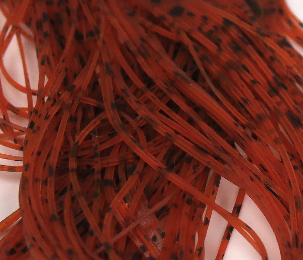 Red-orange translucent buggy nymph legs with black speckles, soft rubber fly tying strands bundled for nymph patterns