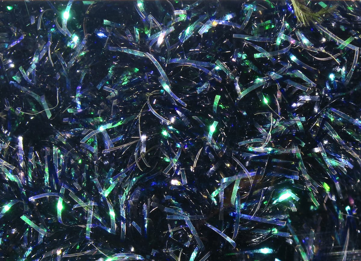 Hareline cactus chenille with dark navy base and iridescent blue-green tinsel fibers, shaggy fly tying material