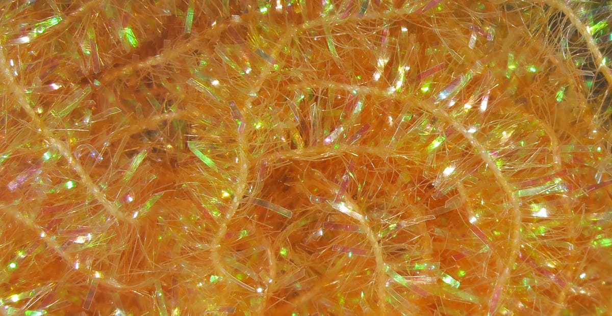 Bright orange cactus chenille with iridescent tinsel strands, fuzzy sparkly texture for fly tying