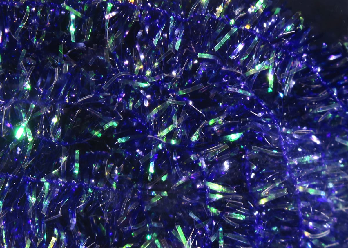 Deep royal blue cactus chenille with iridescent green tinsel flashes and fuzzy texture for fly tying