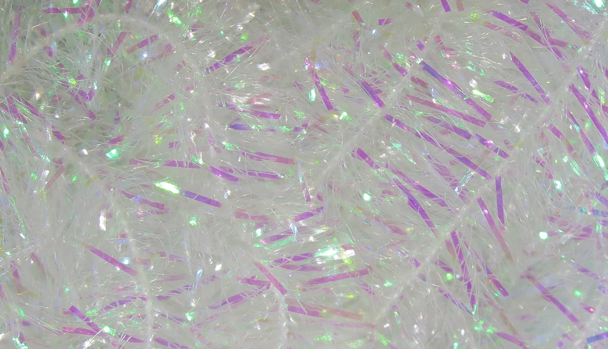 Iridescent white cactus chenille with fine translucent fibers and pink-purple reflective tinsel strips for fly tying