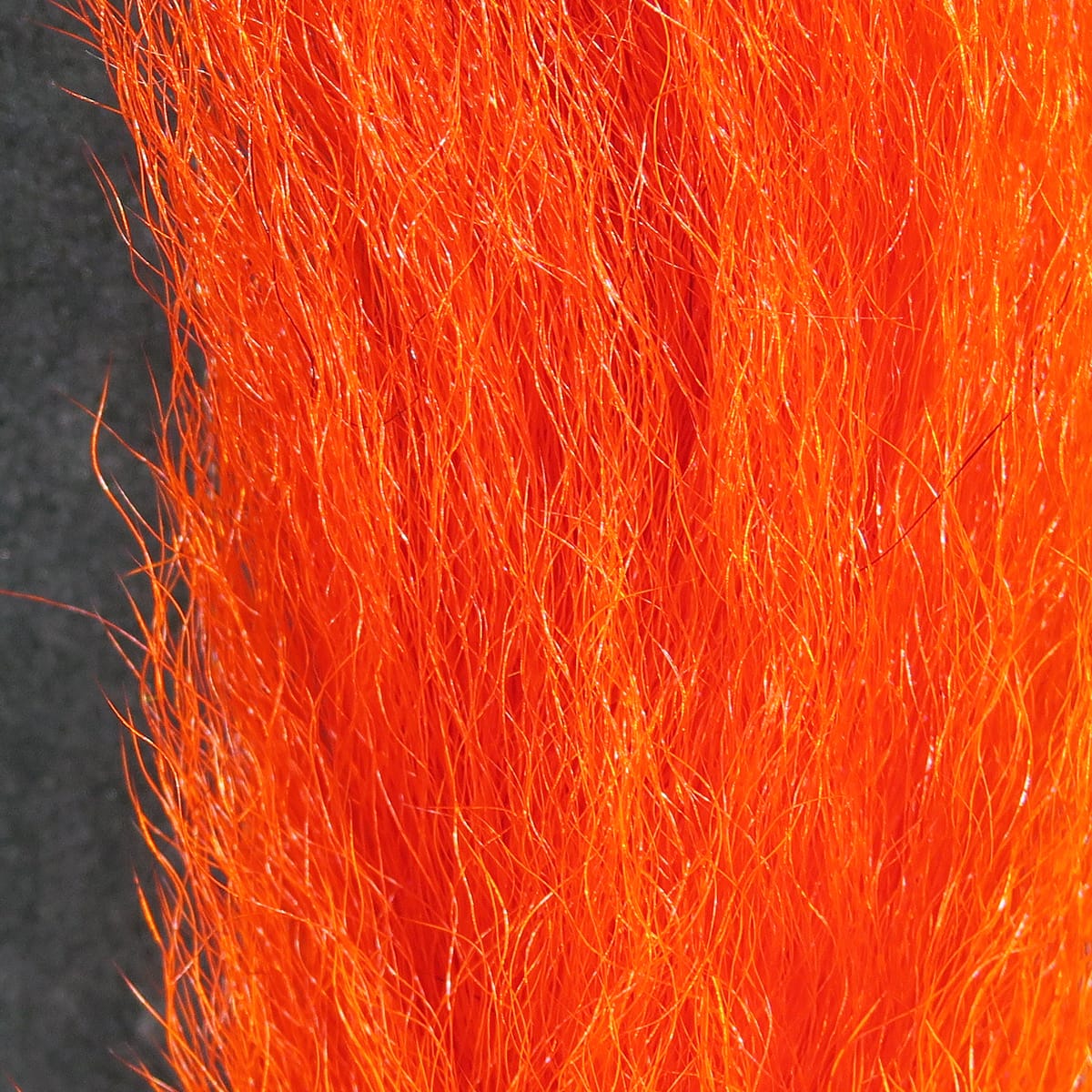 Hareline bright orange calf tails for fly tying, long glossy hair-like fur fibers with subtle sheen