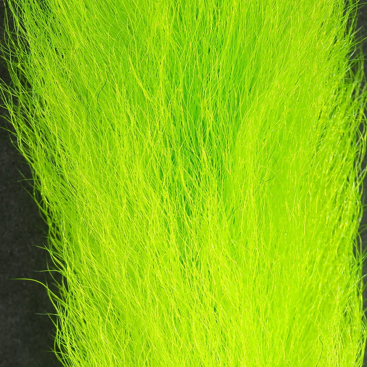 Bright chartreuse Hareline calf tails, long fine fur strands for fly tying in a vibrant neon green bundle