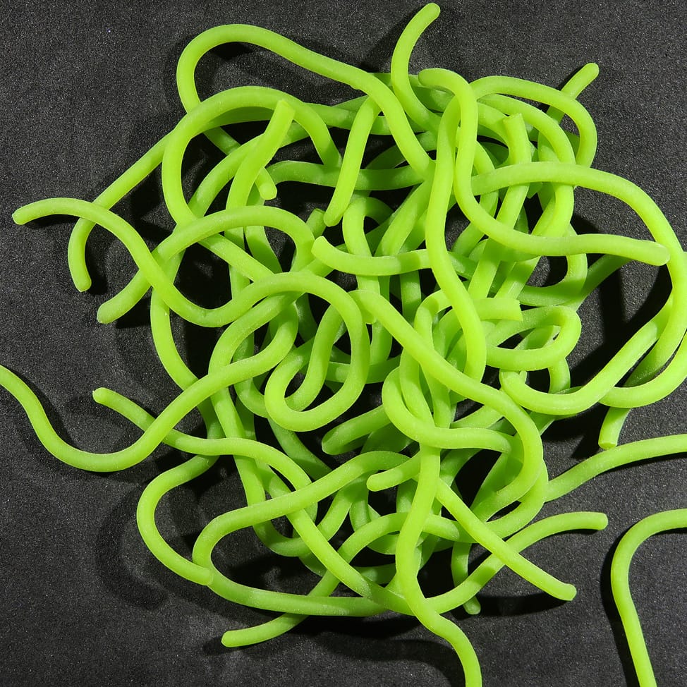 Hareline Squirmito neon chartreuse soft plastic curly tubular tentacles for fly tying on black background