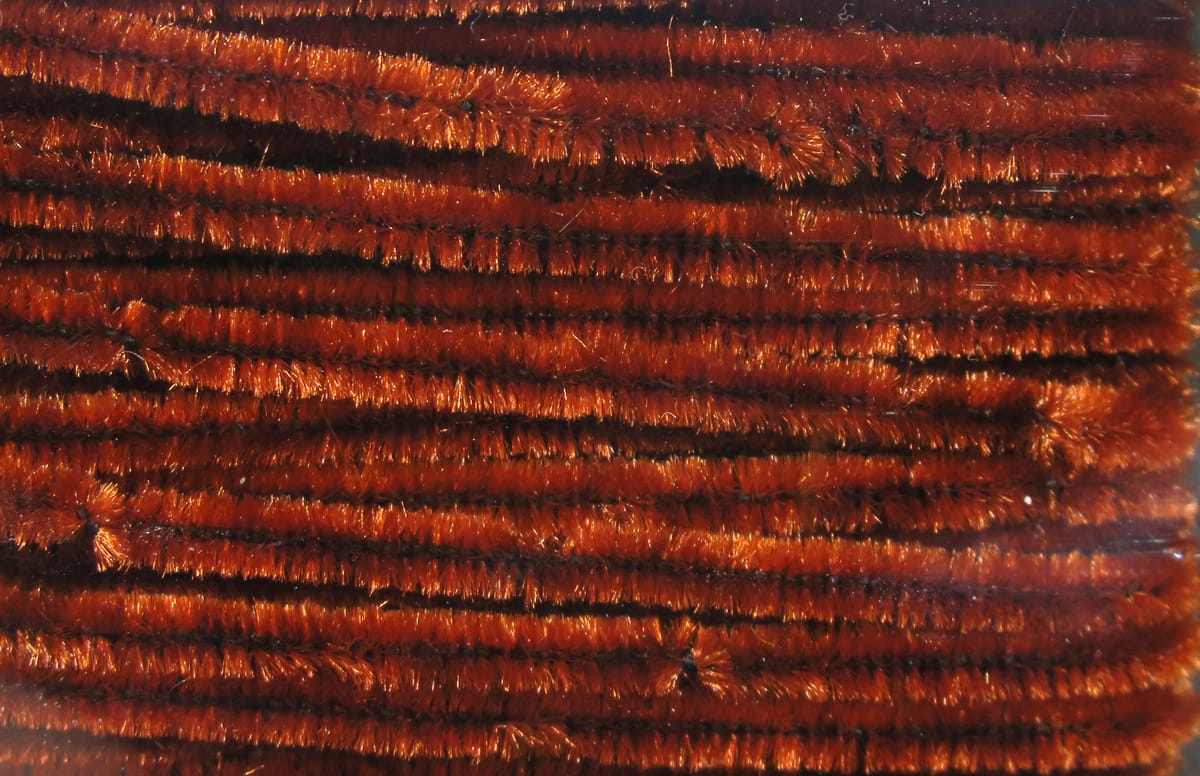 Hareline chenille rust orange metallic fuzzy strands with dense pile and dark core, ideal for fly tying