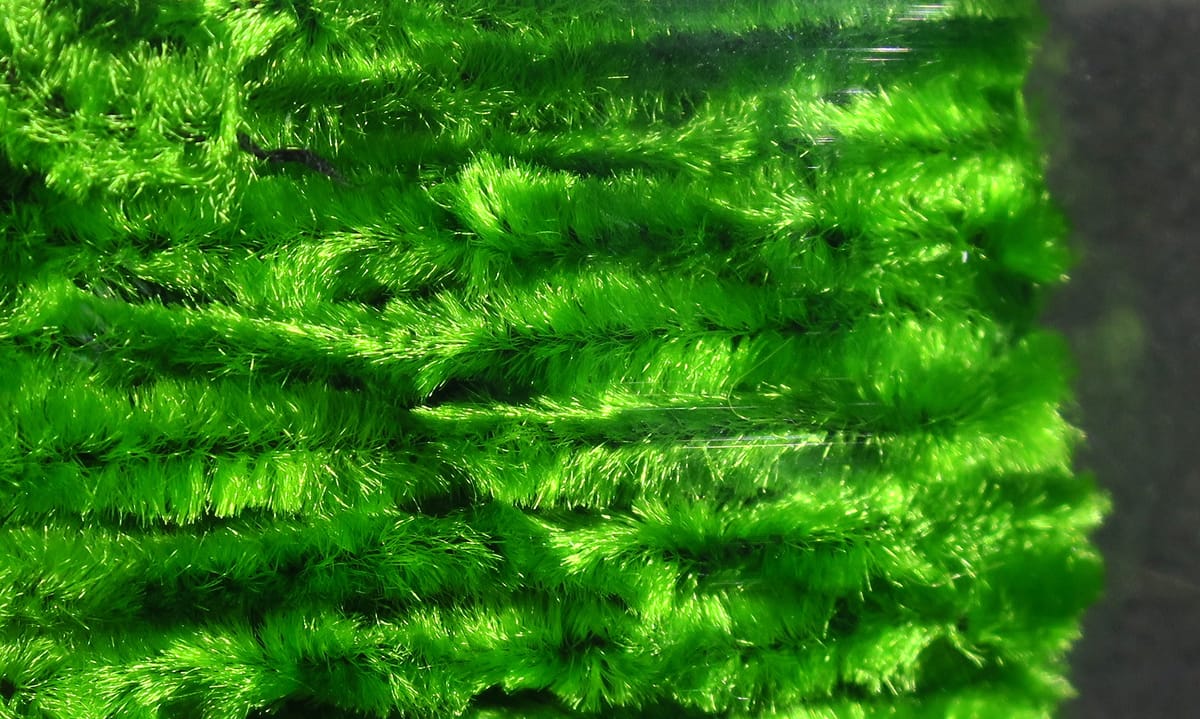 Bright neon green Hareline chenille yarn with plush, fuzzy fibers for fly tying, close-up showing dense tufted texture