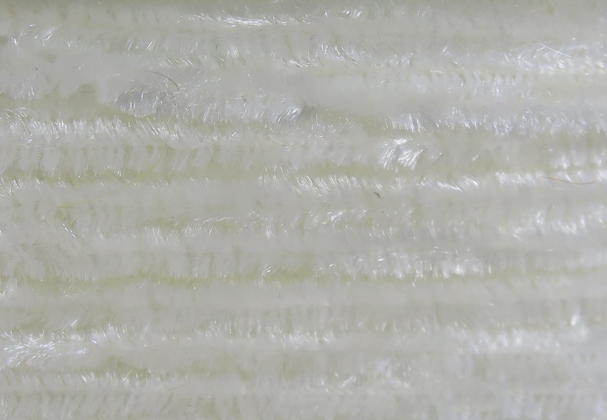 White Hareline chenille rope with soft fuzzy synthetic fibers and subtle iridescent shimmer, fly tying material