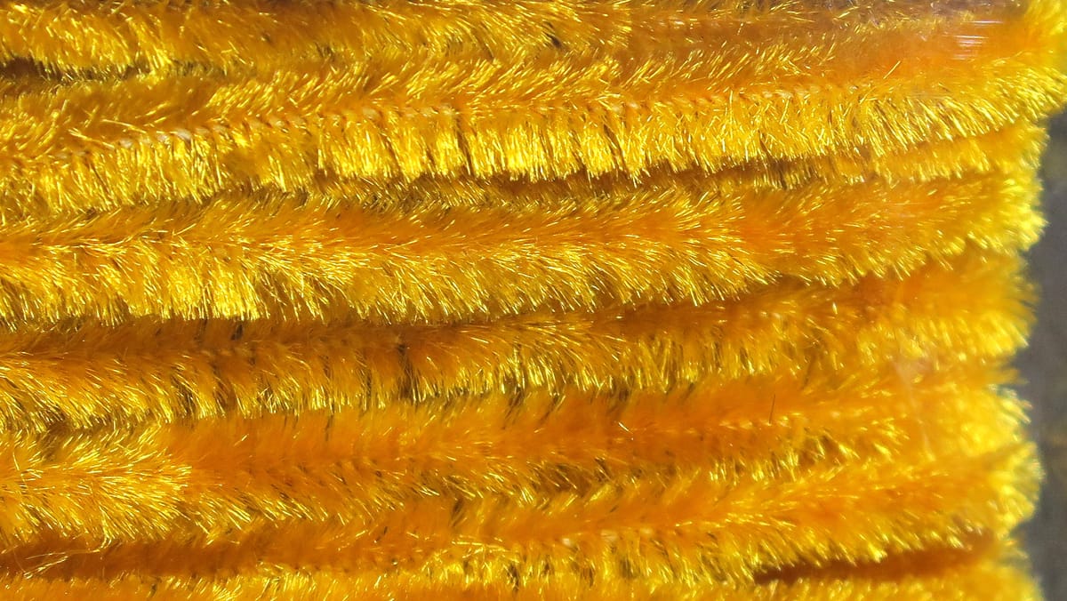 Bright golden yellow Hareline chenille with dense shimmery fuzzy fibers for fly tying