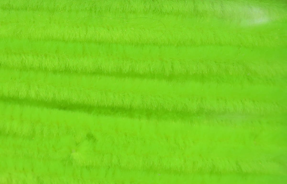 Neon chartreuse Hareline chenille close-up showing fuzzy synthetic fibers in parallel rows for fly tying