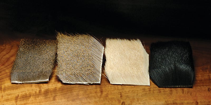 Hareline coastal blacktail deer body hair patches in brown, grizzly tan, cream and black on wood for fly tying