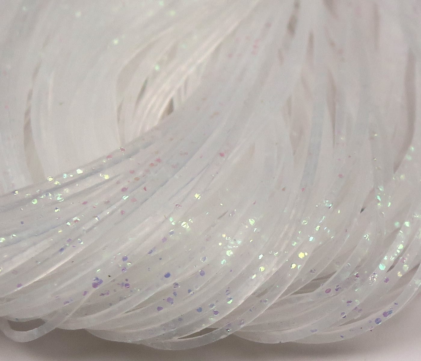 Pearly white translucent silicone Crazy Legs strands with iridescent flakes and purple specks for fly tying