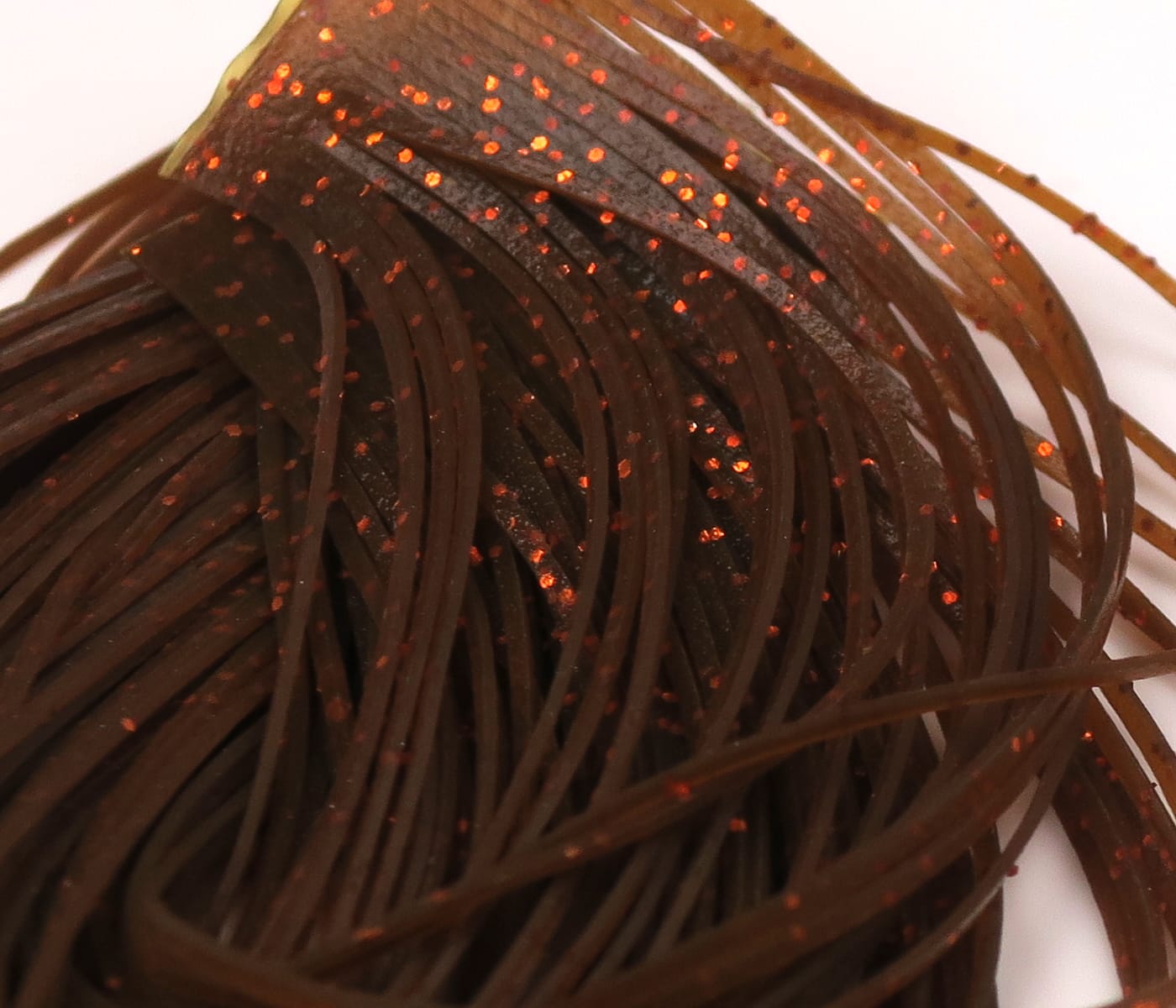 Dark brown rubber legs with orange glitter flecks, thin flat Hareline Crazy Legs strands for fly tying