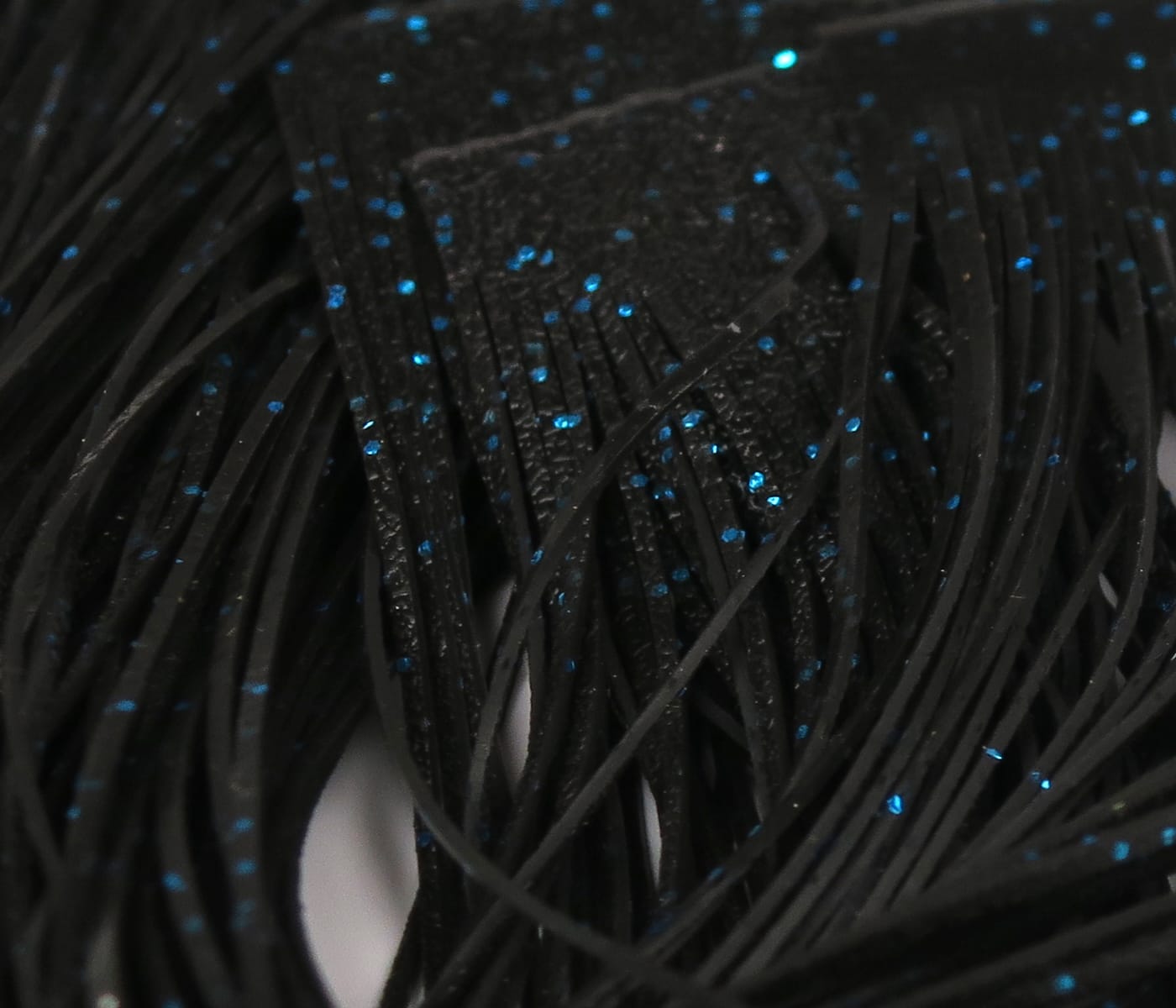 Black rubber fly tying Crazy Legs skirt with thin fringed legs and scattered blue glitter flakes