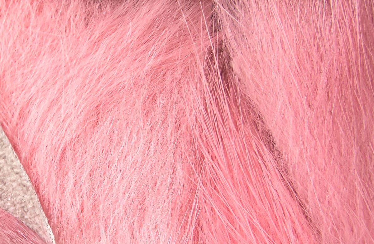Close-up pink dyed rabbit fur strips showing soft guard hairs and dense underfur for fly tying