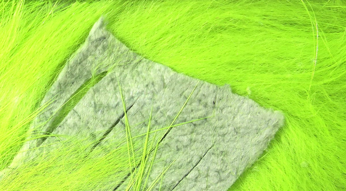 Fluorescent chartreuse Hareline crosscut rabbit fur strips with felt backing and long soft fibers for fly tying