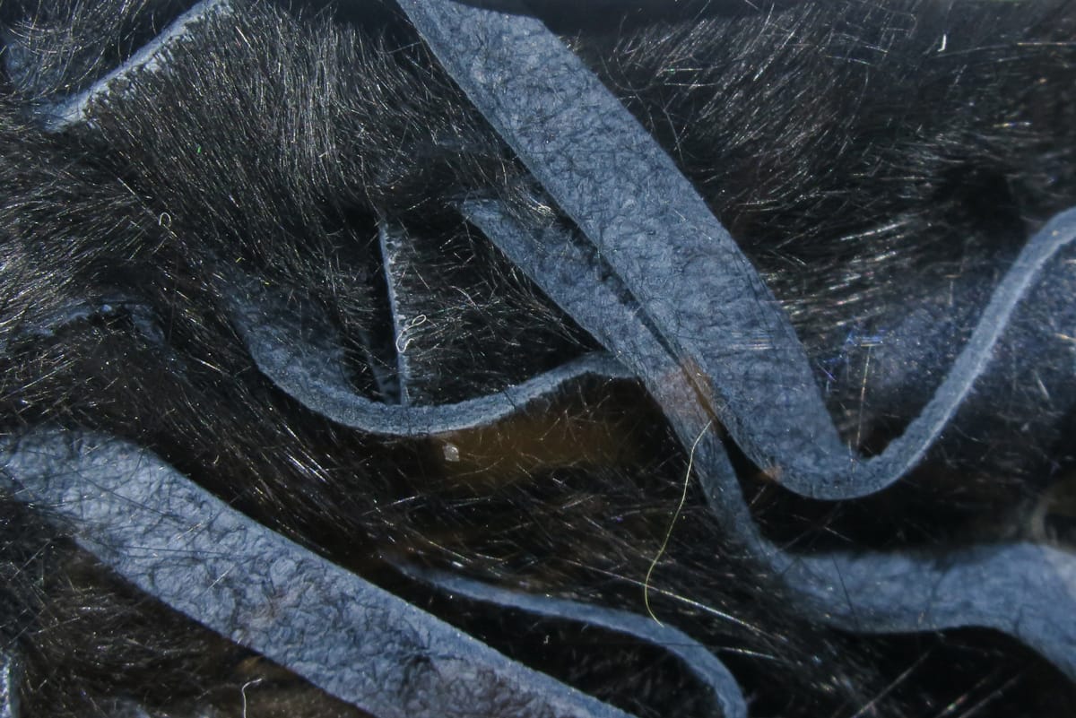 Hareline crosscut rabbit fur strips in dark charcoal with narrow suede backing and fine fur fibers for fly tying