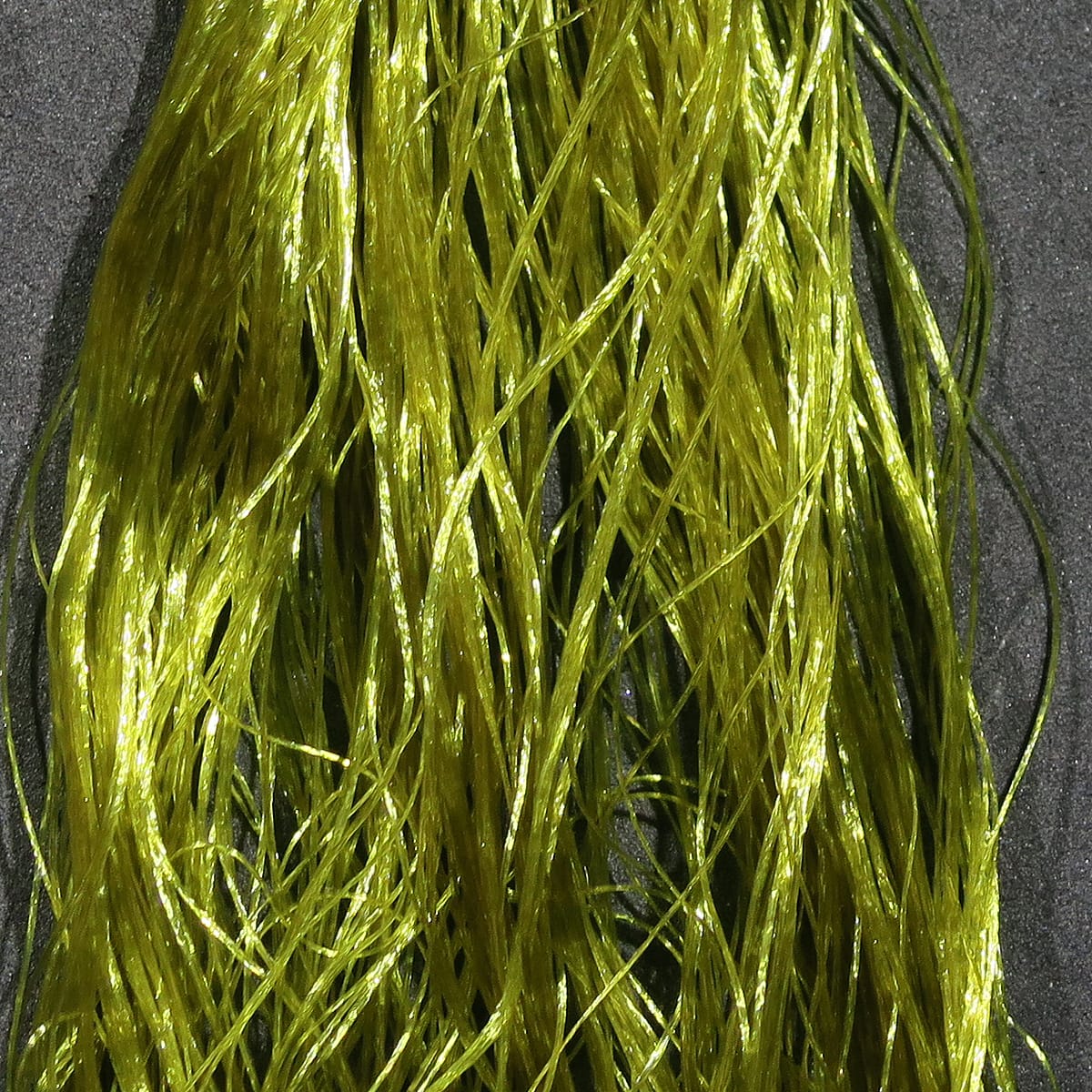 Hareline Daddy Long Legs olive-green shiny synthetic strands, long tinsel-like fibers for fly tying
