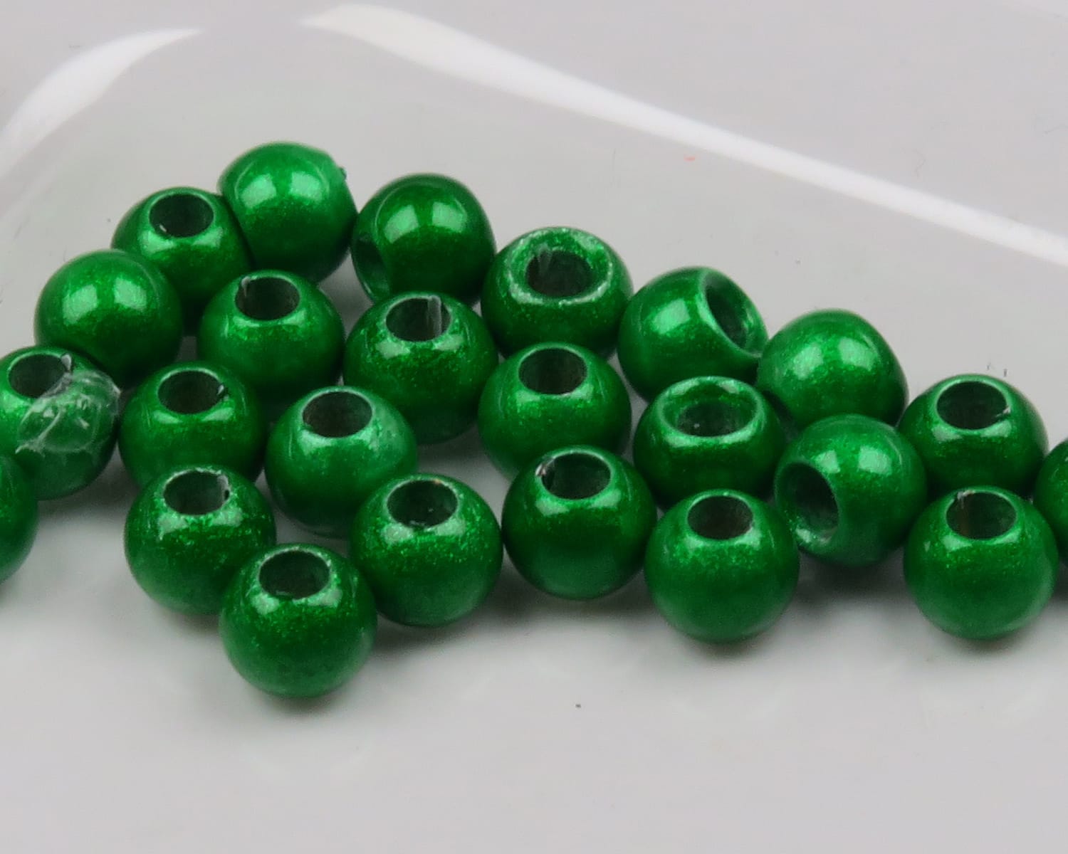 Glossy emerald green brass beads with large holes, Hareline Dazzle finish for fly tying