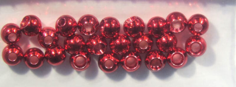Row of shiny red metallic Hareline Dazzle brass beads with center holes, reflective finish for fly tying