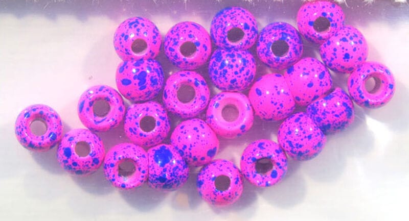 Bright pink Hareline Dazzle brass beads with blue speckles, donut-style fly tying beads with large holes