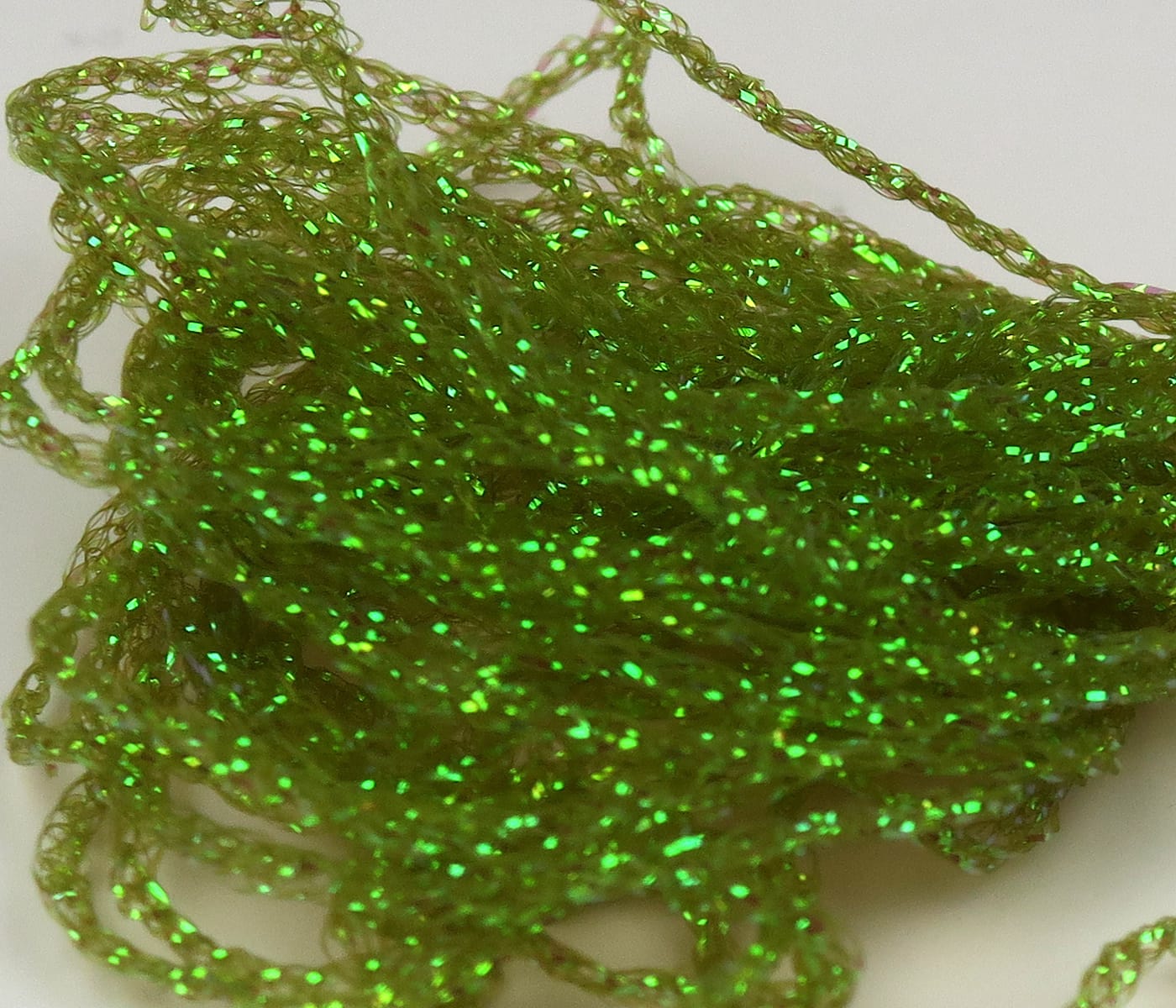 Chartreuse green Diamond Braid shiny holographic braided synthetic fibers for fly tying in a loose tangled bundle